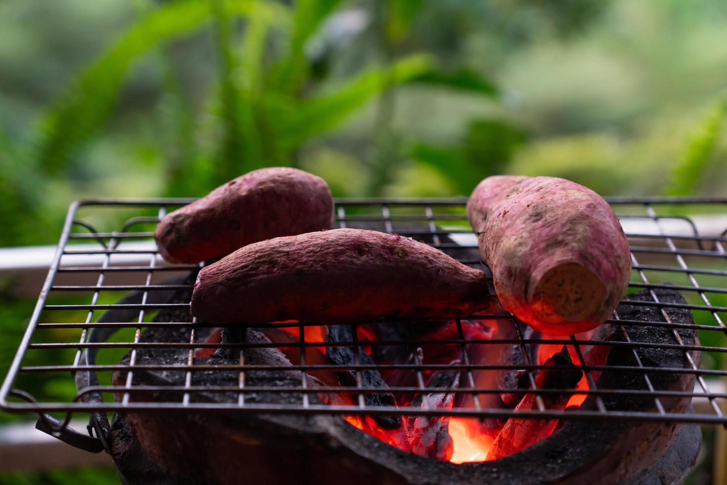 camote asado con charoal en la estufa foto