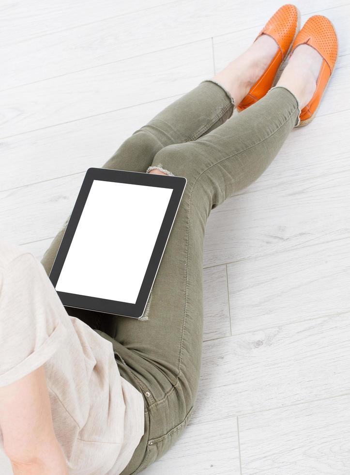 tablet with a blank display on the girl's lap at home photo
