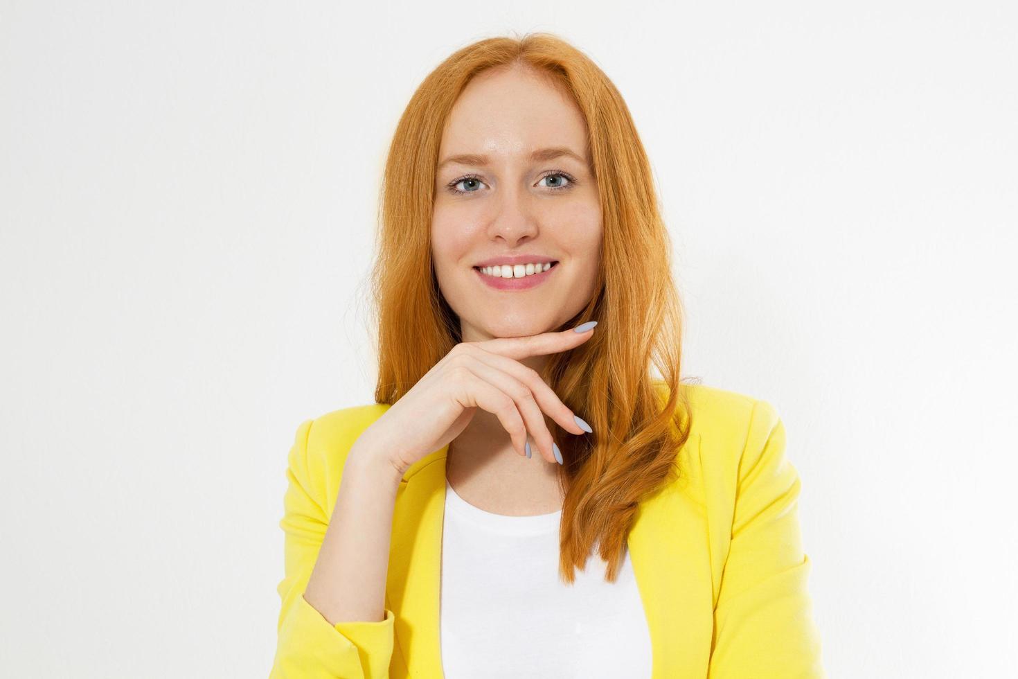 Feliz hermosa joven pelirroja en un elegante espacio de copia de chaqueta amarilla. atractiva chica de pelo rojo mirando a otro lado. foto