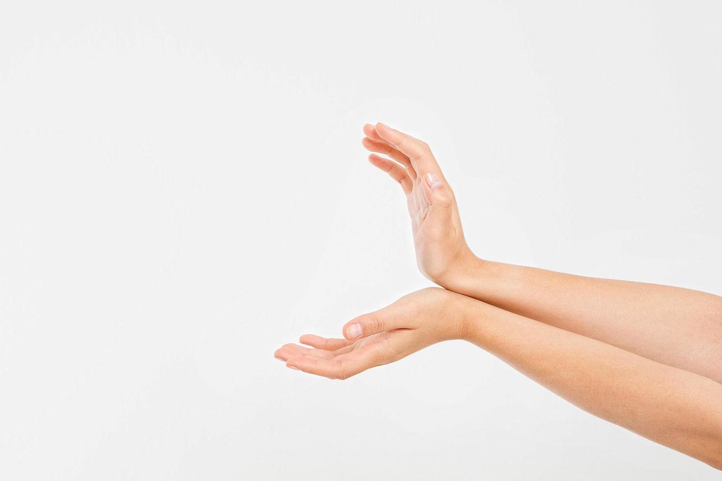 Manos femeninas midiendo elementos invisibles, la palma de la mujer haciendo un gesto mientras muestra una pequeña cantidad de algo sobre fondo blanco aislado, vista lateral, primer plano, recorte, espacio de copia foto