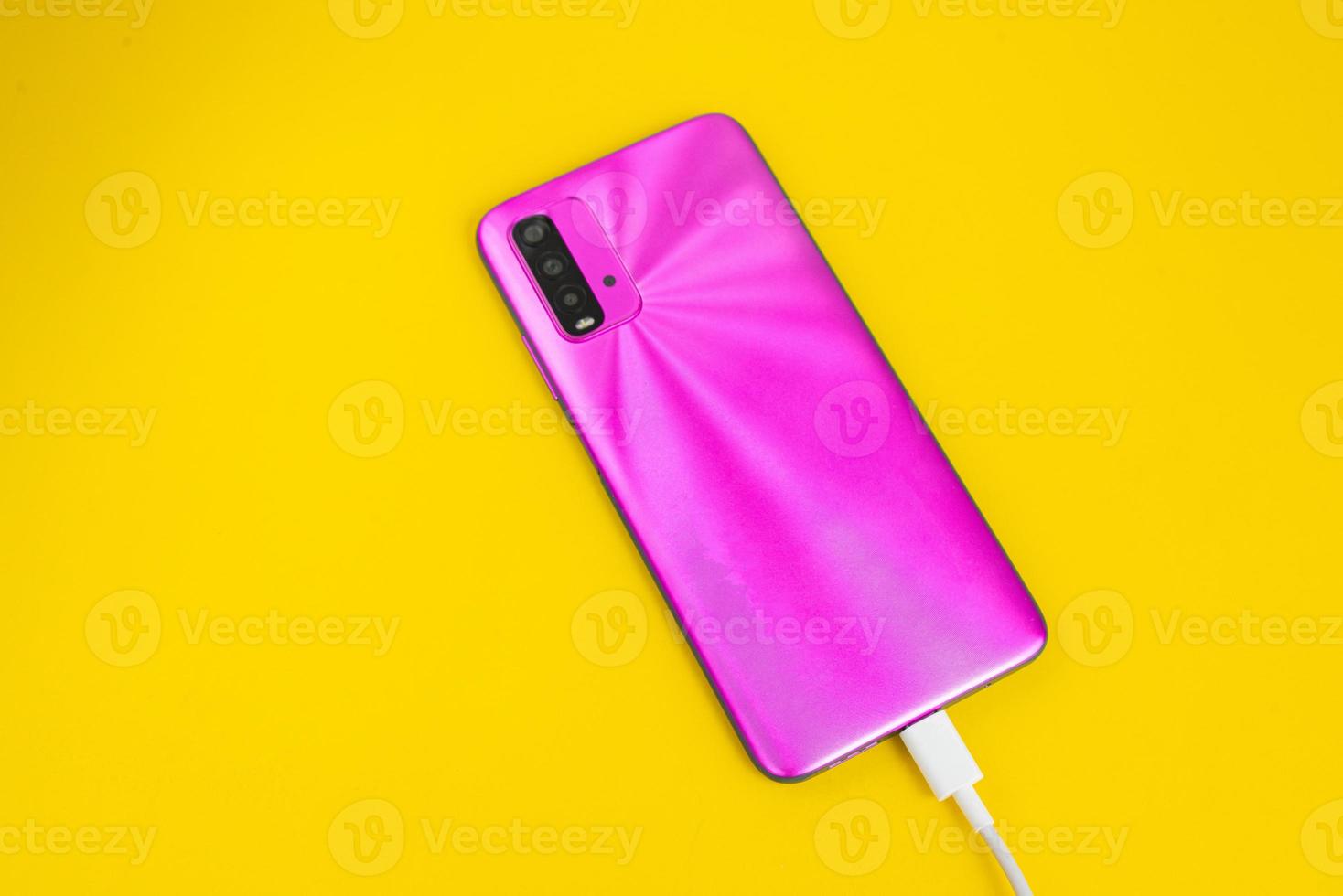 teléfono celular rosa conectado a cable usb tipo c - cargando foto