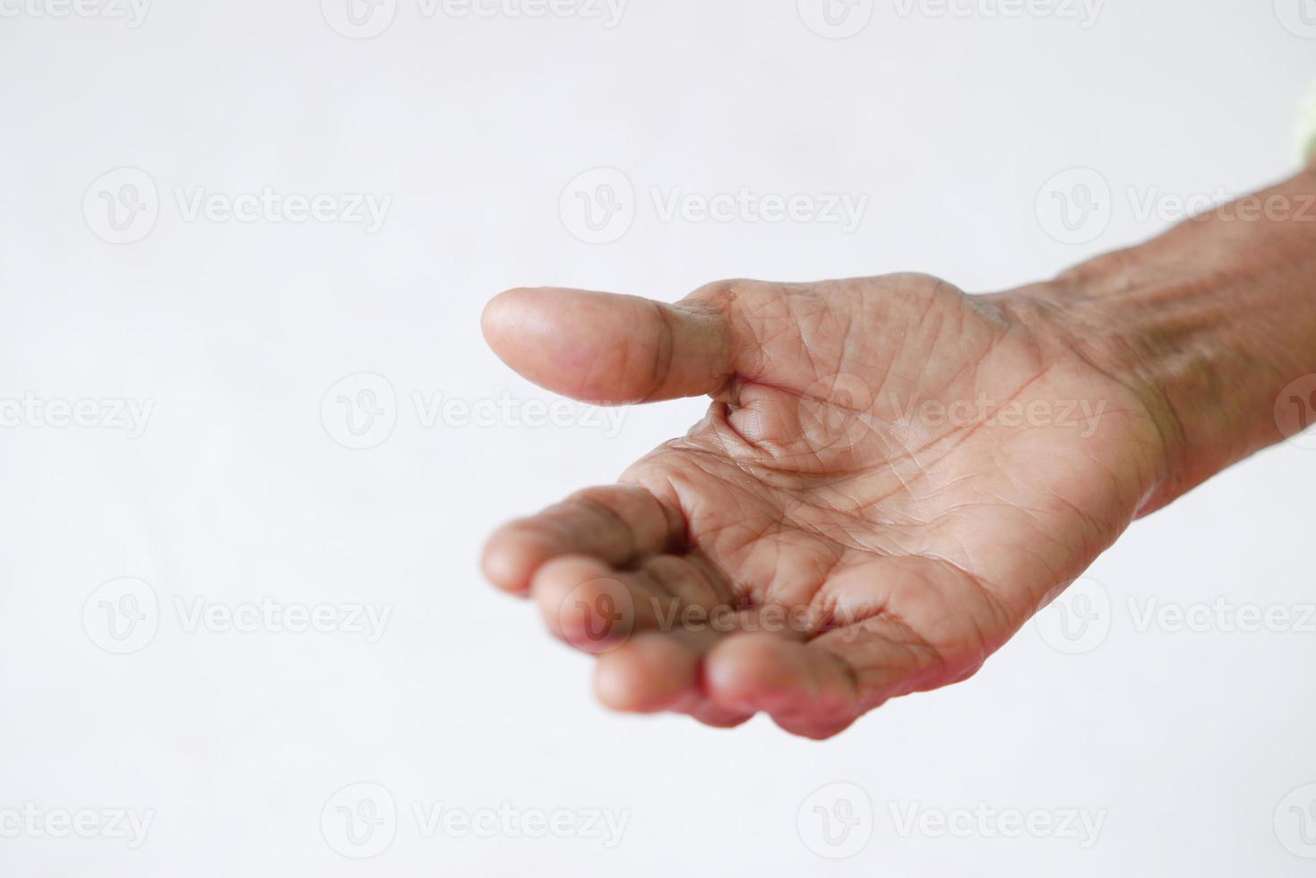 Cerca de la mano de una persona mayor aislado en blanco foto