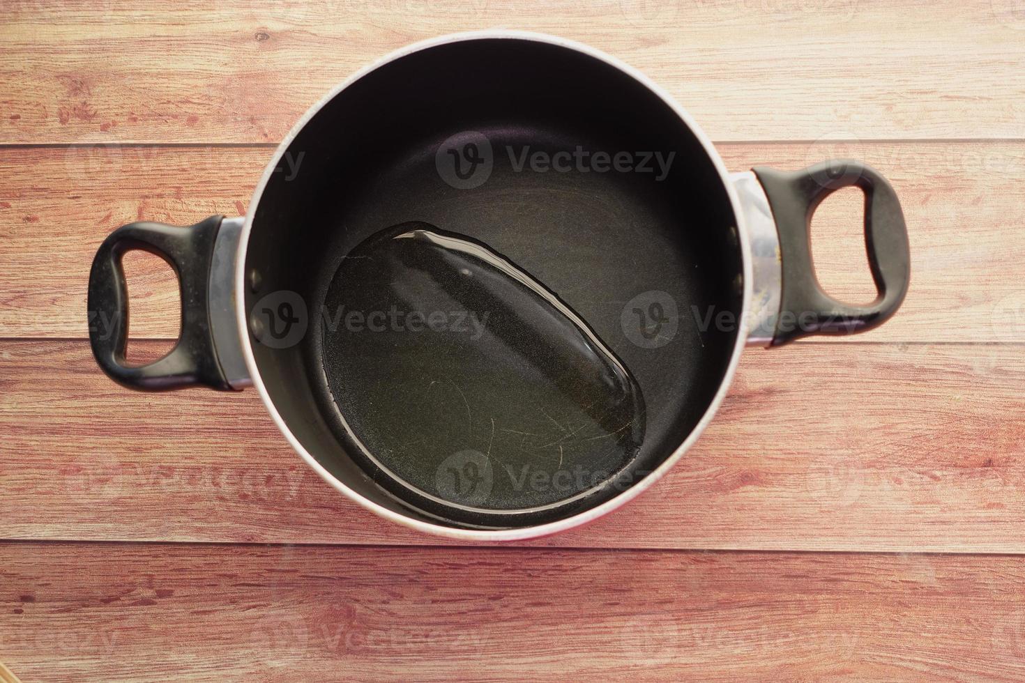 top view of Pouring vegetable oil into frying pan. photo