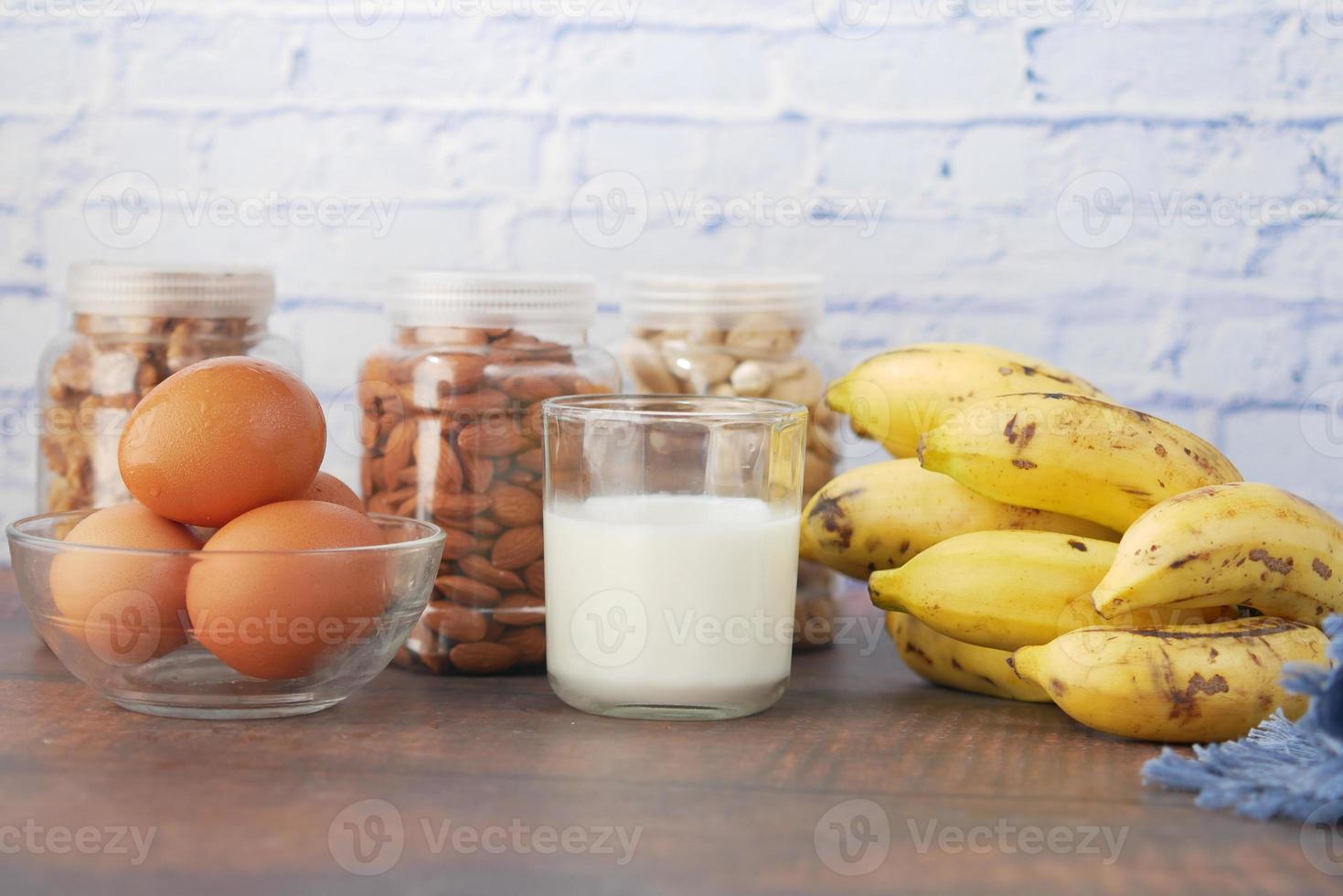 eggs in a plastic container, milk and almond nut in table photo