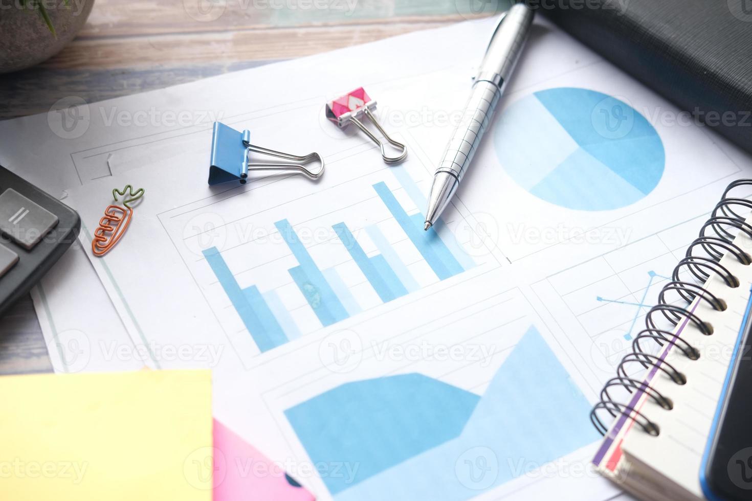 financial graph, calculator and notepad on table photo