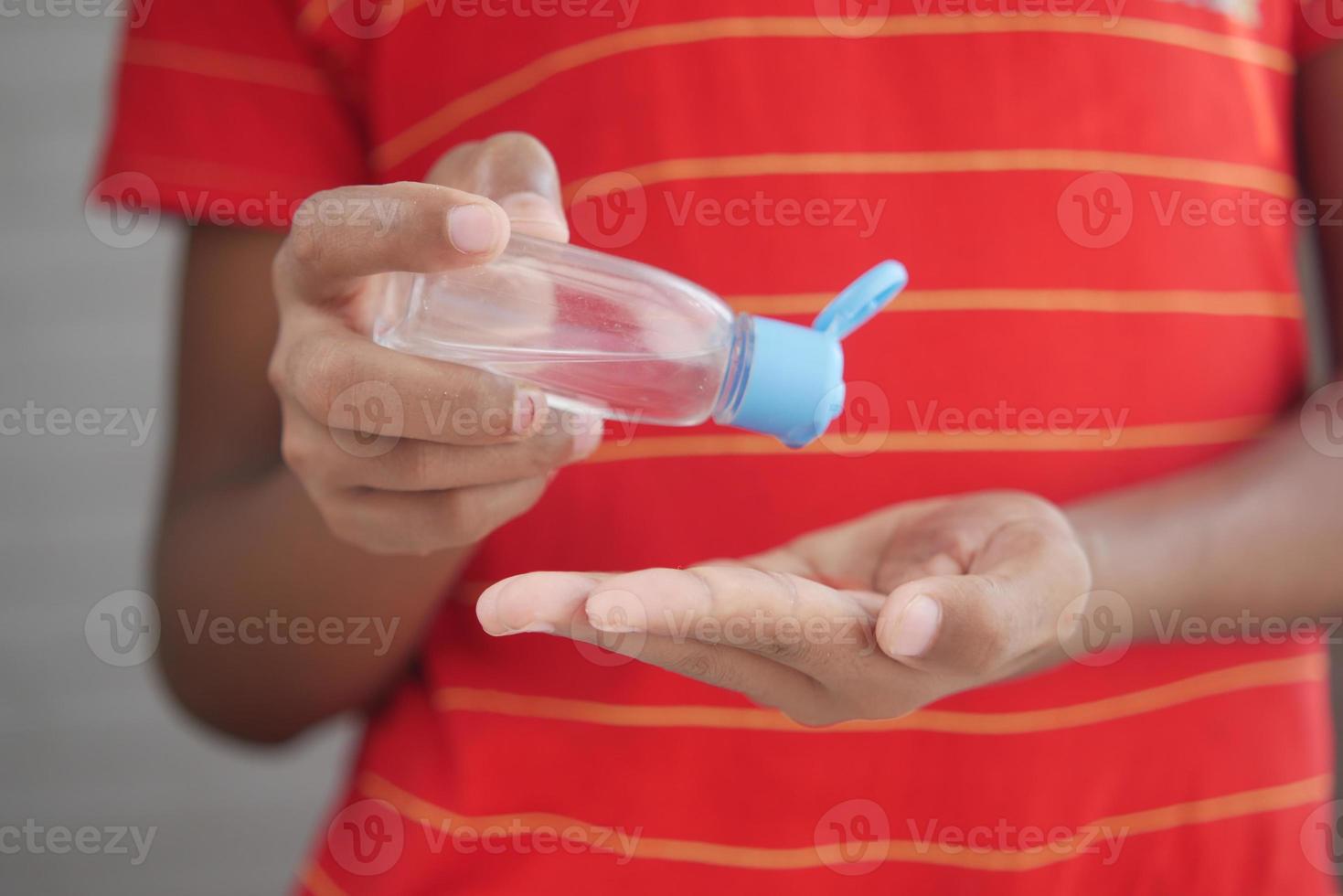 Mano de niño usando gel desinfectante para prevenir virus con espacio de copia foto