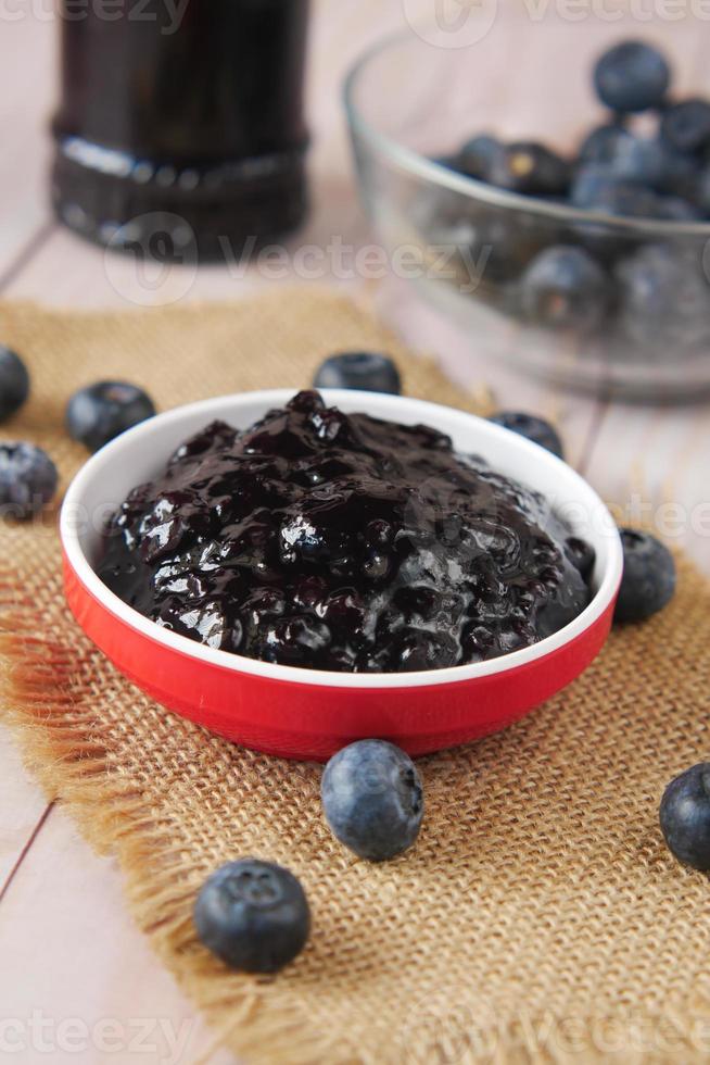 blue berry jam in container on table photo