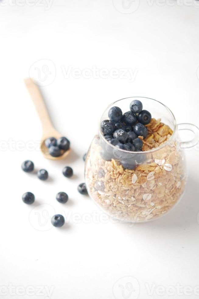 Desayuno de cereales y bayas azules en un tazón en la mesa foto