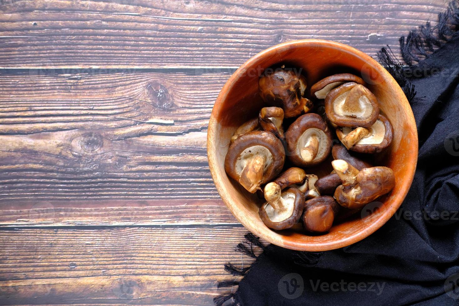 Setas champiñones crudos en un recipiente sobre la mesa foto