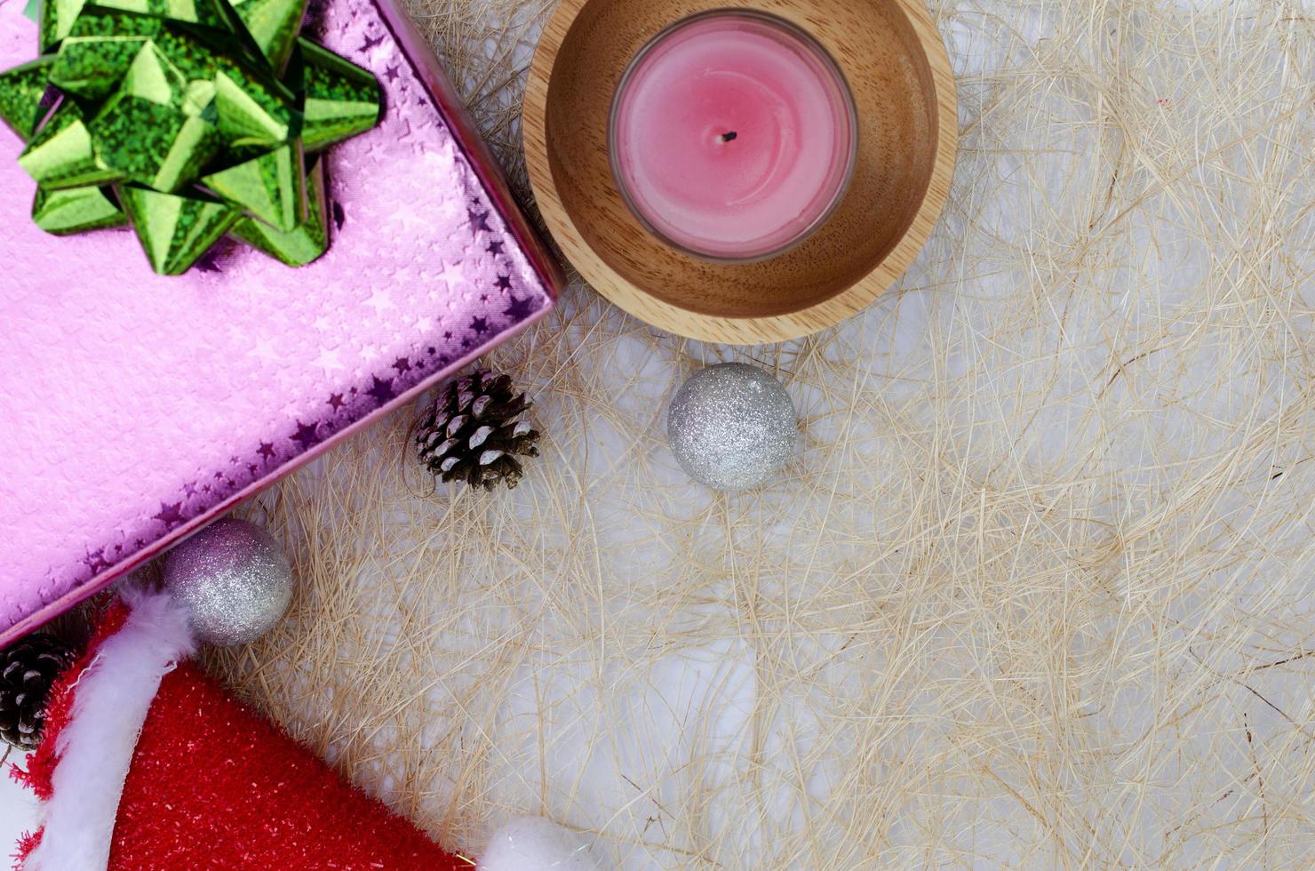 Fondos navideños con vela y caja de regalo rosa con espacio para texto foto