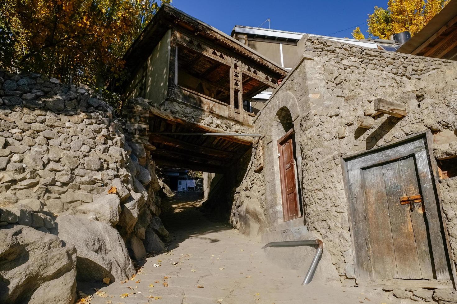 Gilgit, Baltistán, Pakistán, 2017 - una estrecha calle de piedra hacia la antigua fortaleza de Baltit, con un antiguo corredor de madera en Karimabad, Hunza Valley foto