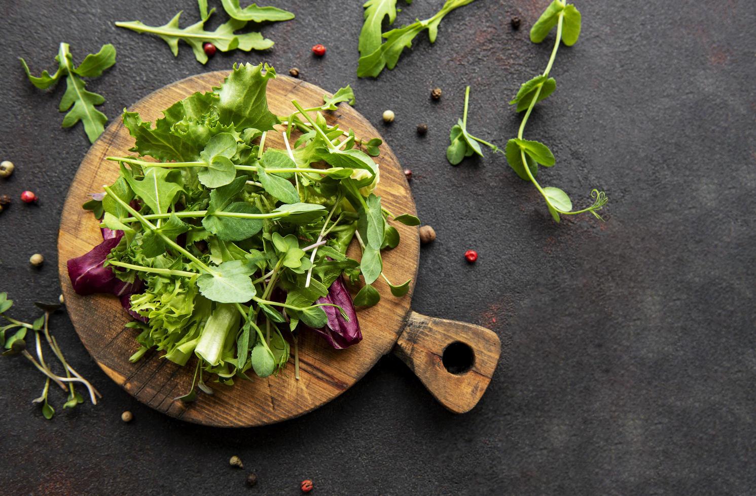 Ensalada saludable, ensalada de mezcla de hojas sobre una tabla de madera foto