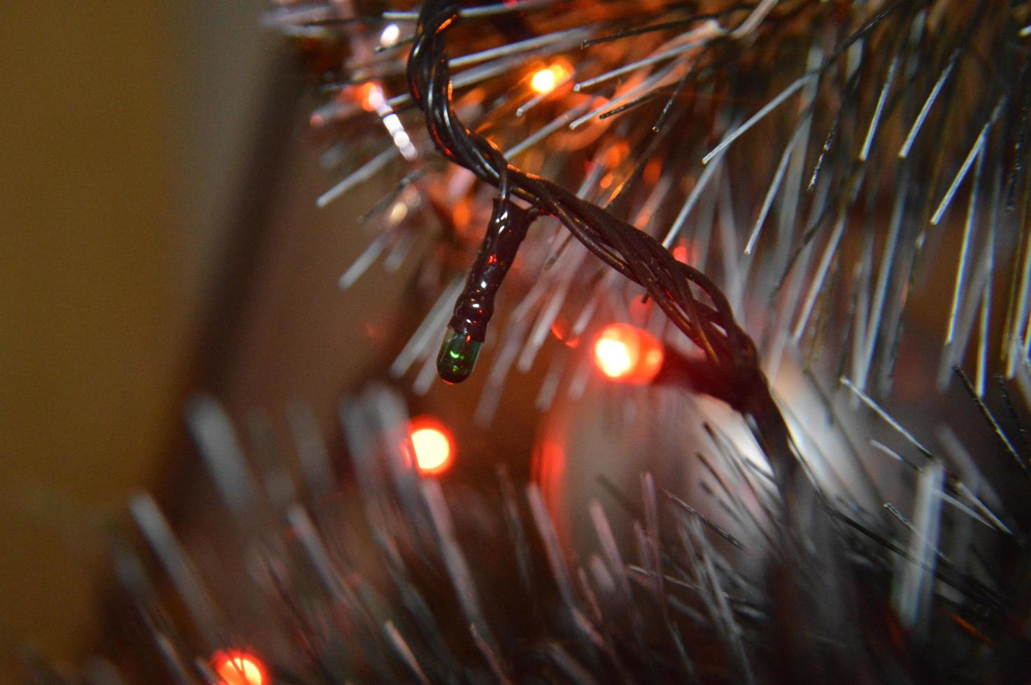 árbol de navidad con juguetes y guirnaldas luminosas en casa y en el fondo de la oficina foto