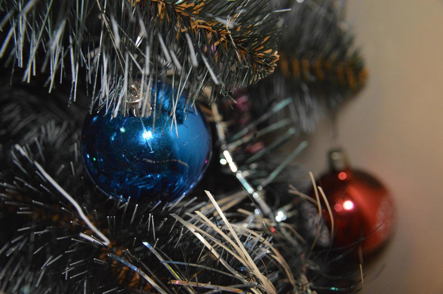 árbol de navidad con juguetes y guirnaldas luminosas en casa y en el fondo de la oficina foto