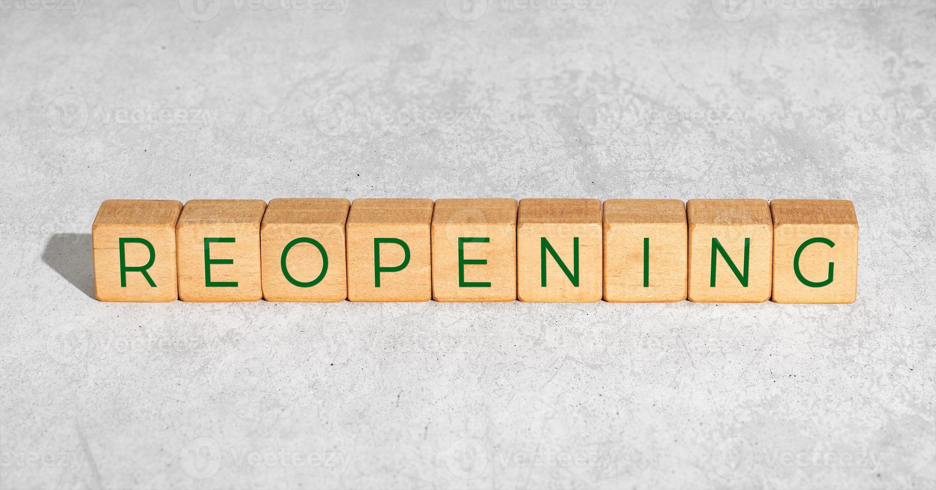 Reopening concept after the coronavirus pandemic. Wooden blocks with text isolated on concrete background photo