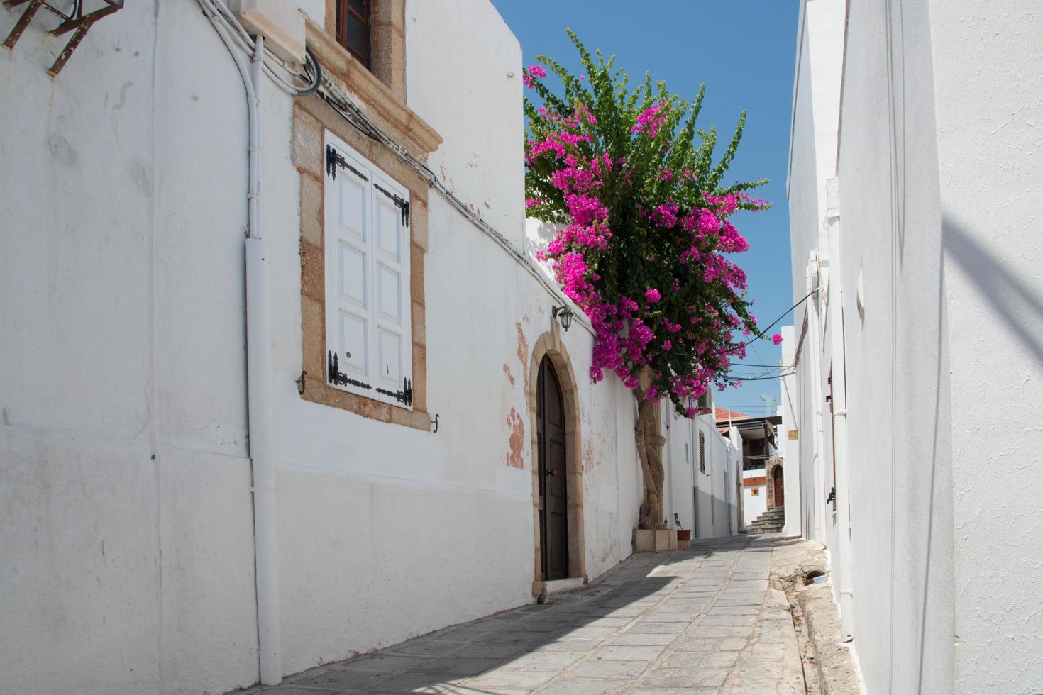Hermosa calle vacía en Lindos, Rodas, Grecia en un día soleado foto