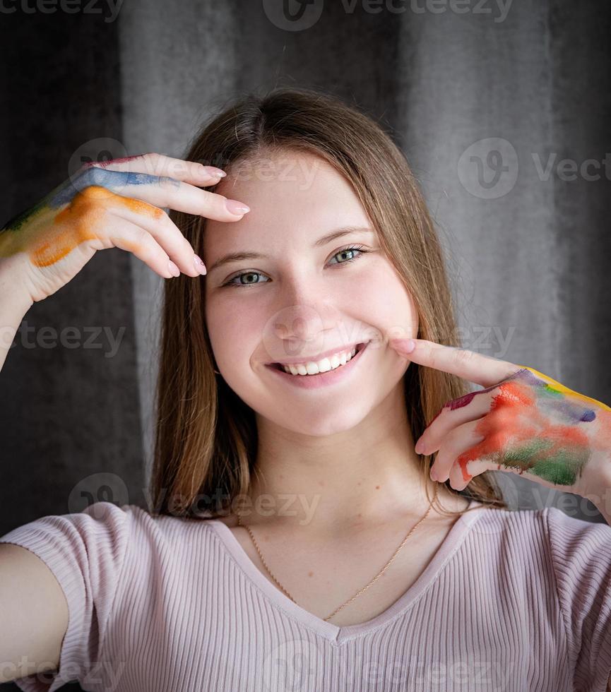 Portrait of a smiling artist woman with colored hands photo