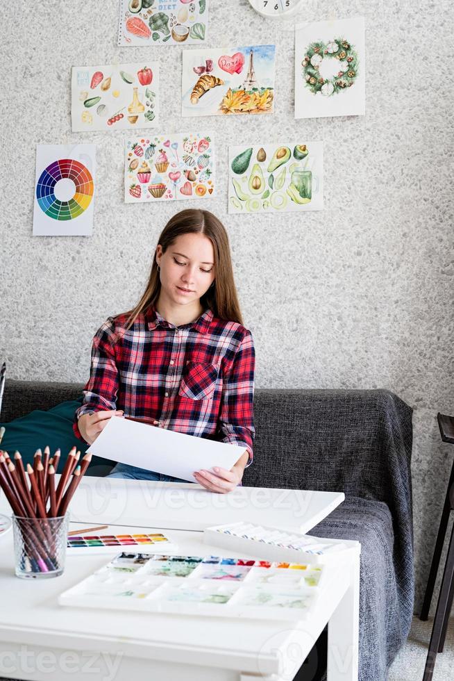 hermosa mujer artista pintando un cuadro en casa foto