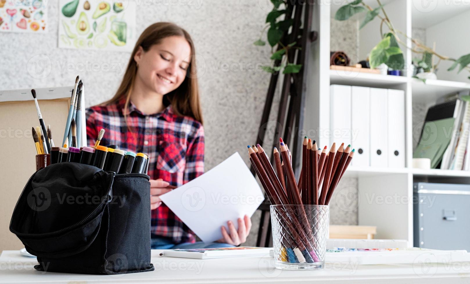 Beautiful woman artist painting a picture at home photo