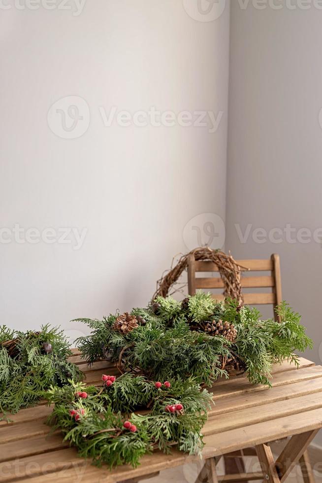 Various christmas wreathes on wooden table in home interior photo