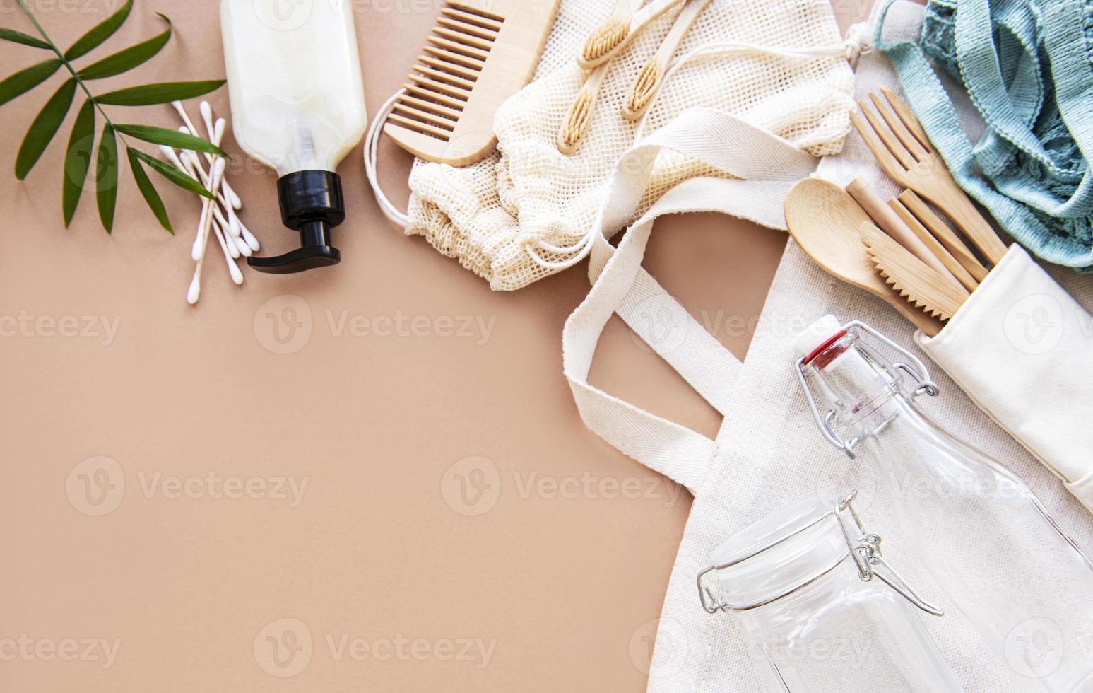 Cotton bags, net bag with reusable  glass jars, bamboo and wooden cutlery on brown background. Zero waste concept. Eco friendly. Flat lay photo