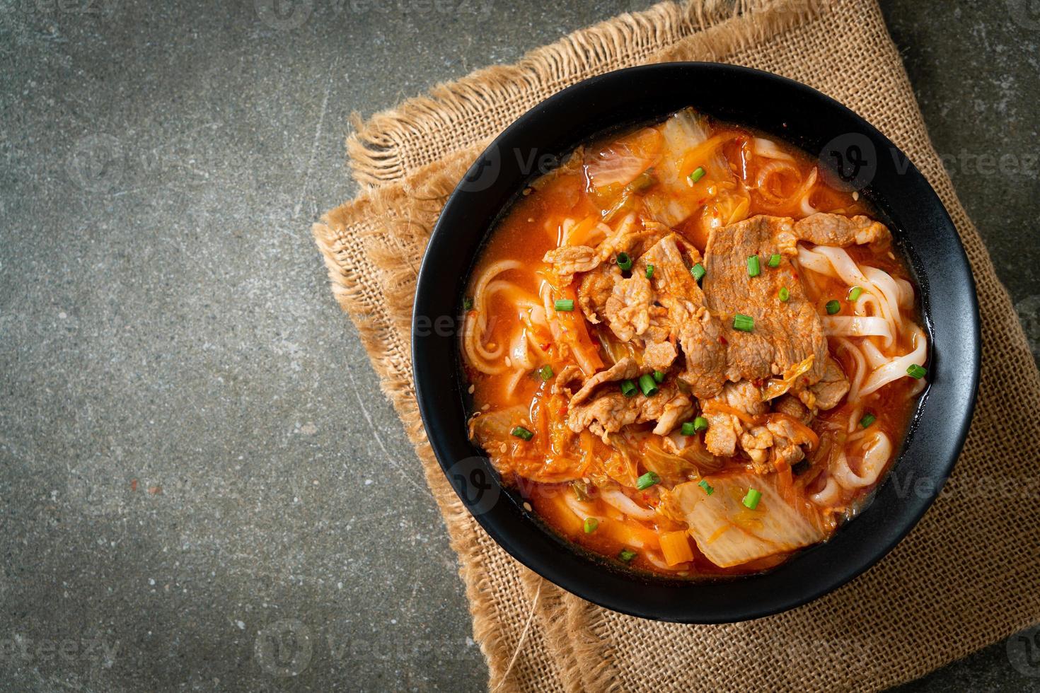 Korean udon ramen noodles with pork in kimchi soup photo