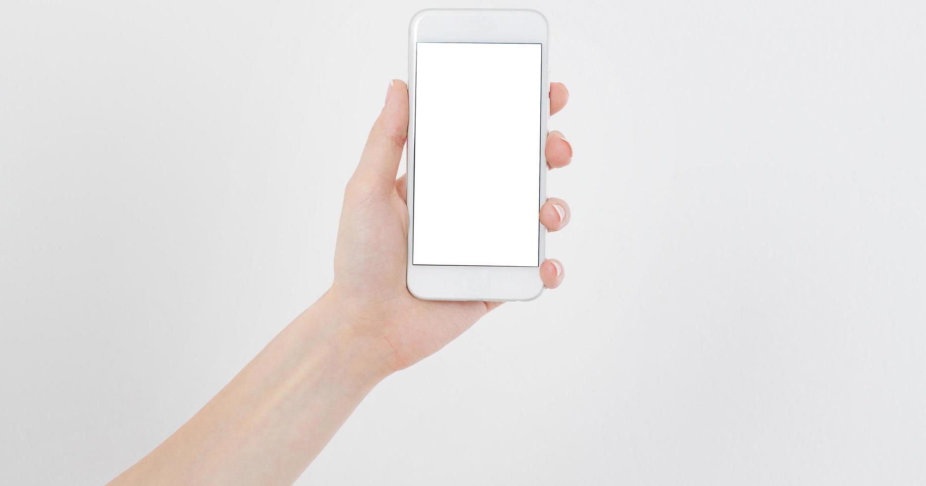 Asimiento de la mano femenina teléfono móvil aislado en blanco, mujer sosteniendo el teléfono con pantalla vacía, pantalla en blanco, tocando foto