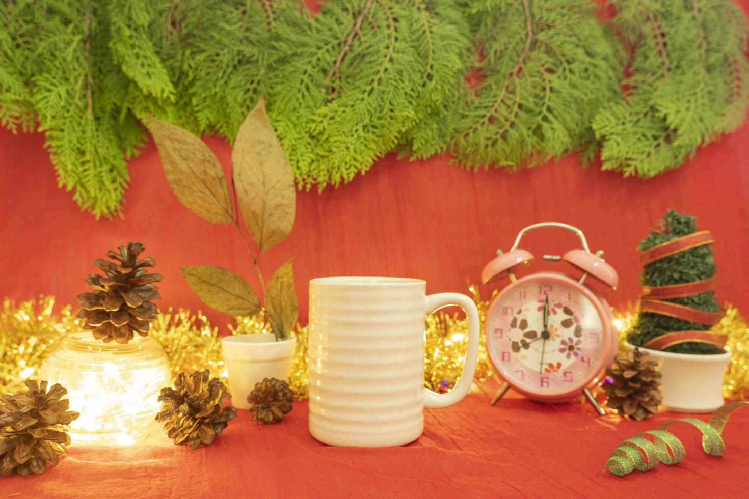 Minimalist concept idea displaying products. coffee mug on christmas and new year background.red, lights, pine flowers photo