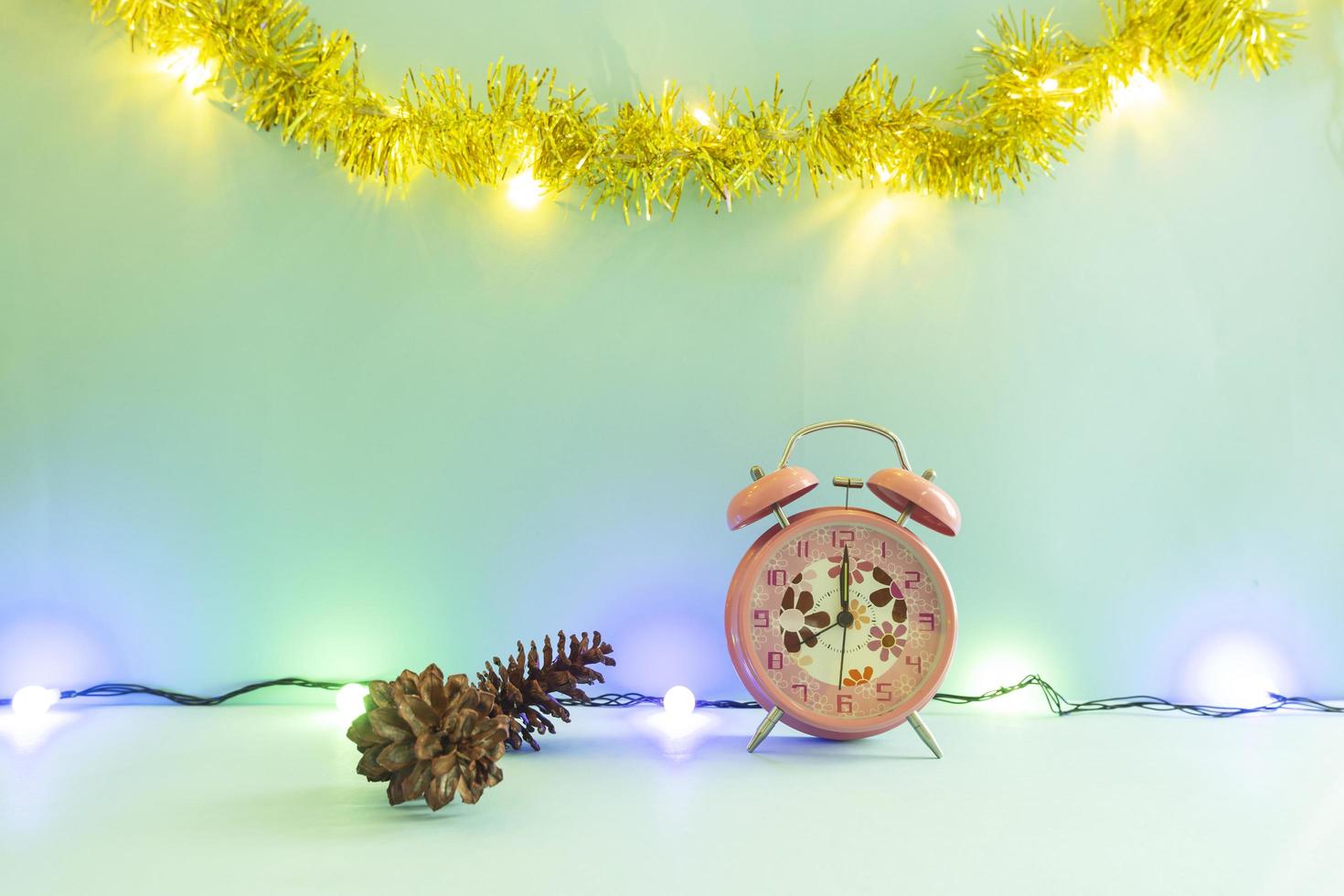 Minimalist concept idea displaying products. christmas and new year backgrounds. alarm clock. pine flower photo