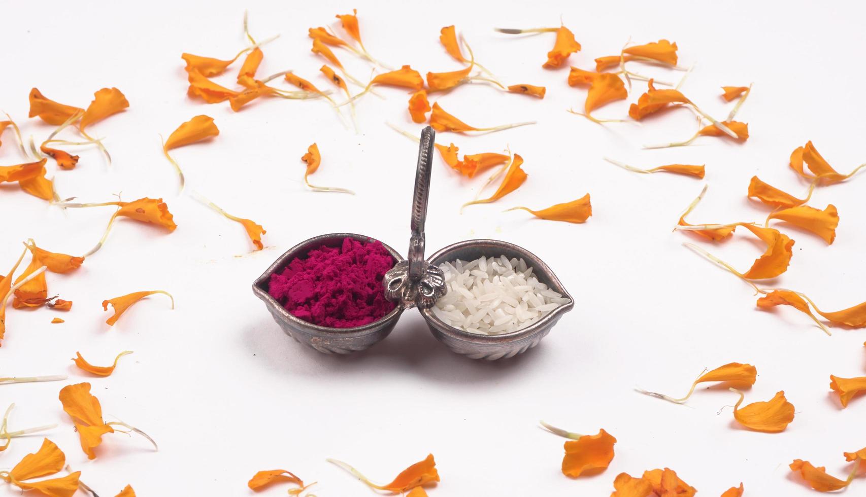 Indian Festival Dussehra, showing golden leaf and flowers with Kumkum and rice on moody background. Greeting card. photo