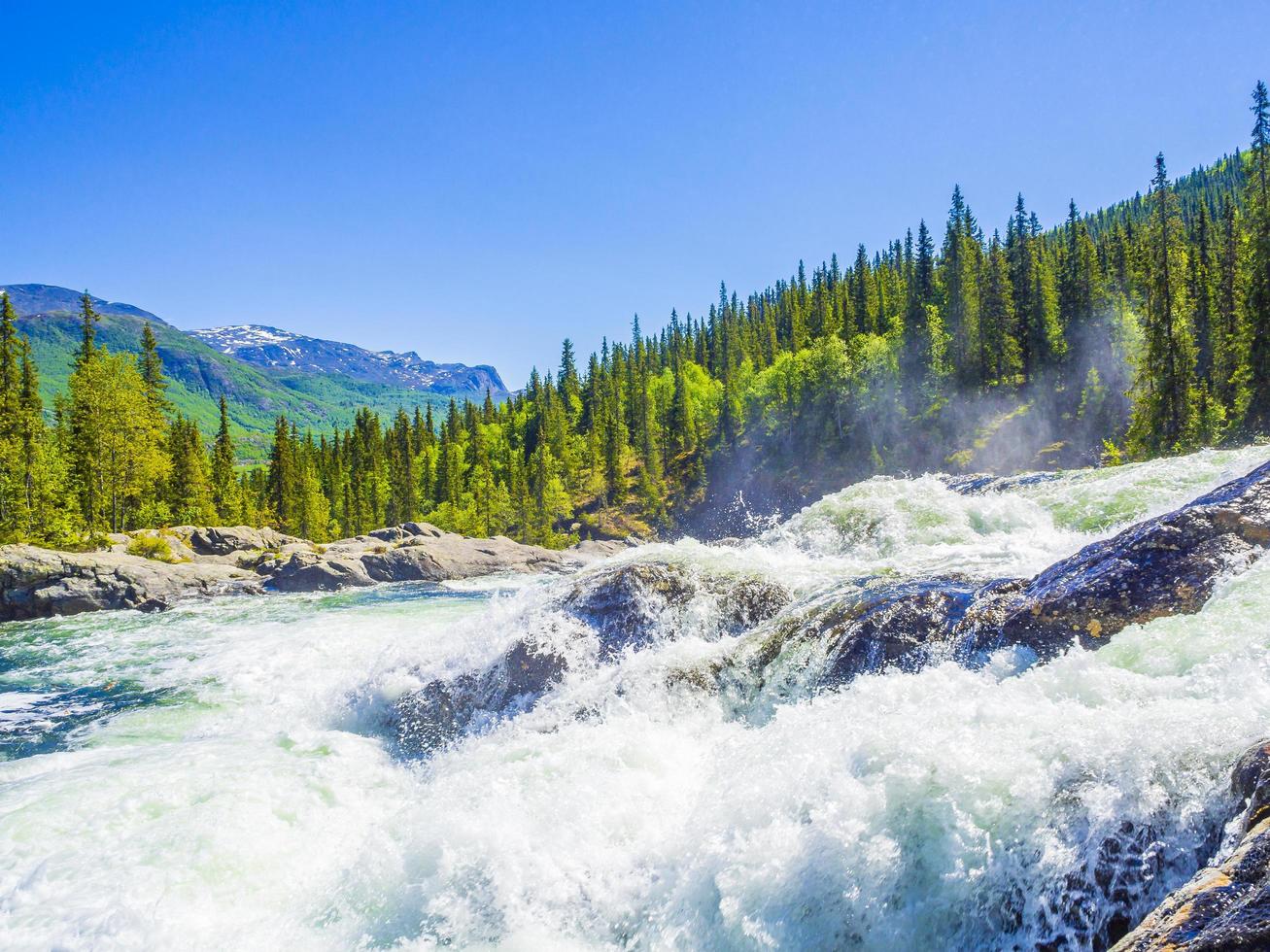 El agua del río que fluye rápido de la hermosa cascada rjukandefossen hemsedal noruega. foto