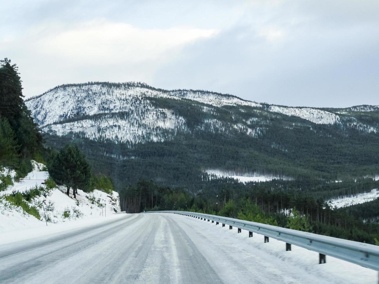 Driving through snowy white road and landscape in Norway. photo