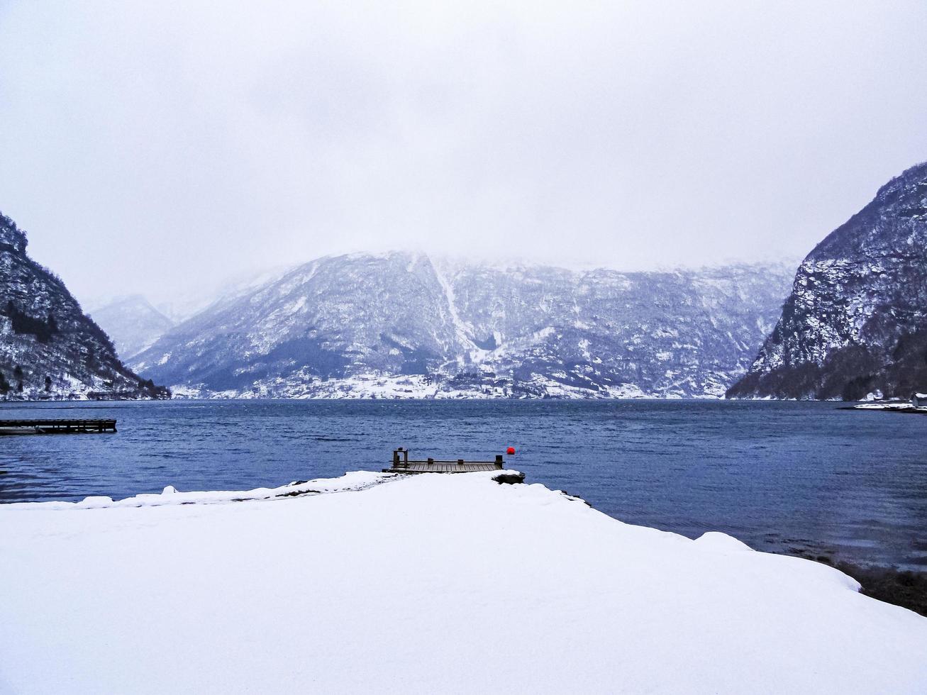 Embarcadero en un paisaje invernal en el lago Fjord, Noruega. foto