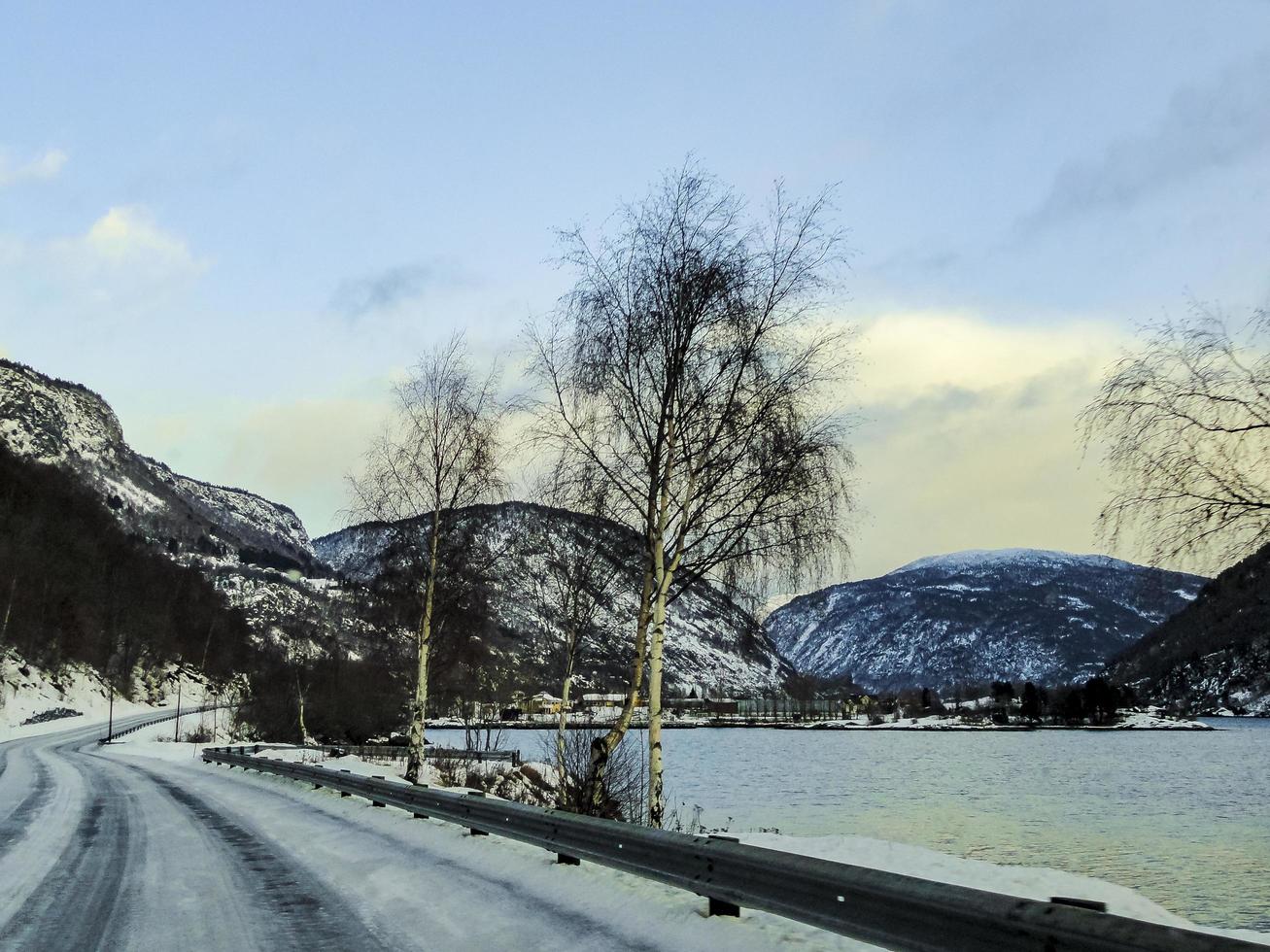 conduciendo al amanecer por el fiordo sobre hielo negro, noruega. foto