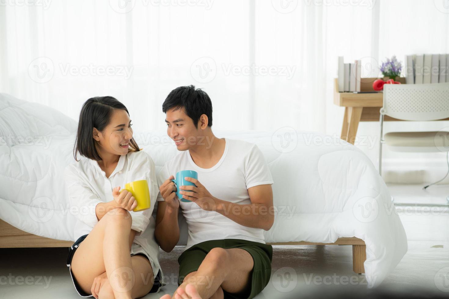 las parejas están felices de relajarse en el dormitorio blanco foto