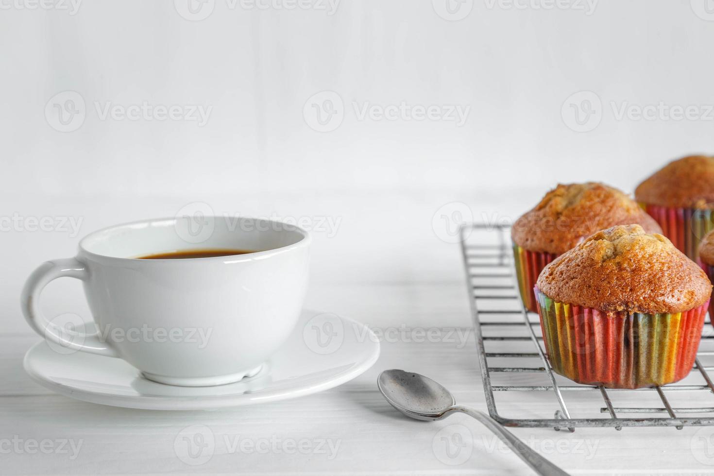 Cupcakes caseros y taza de café en el cuadro blanco foto