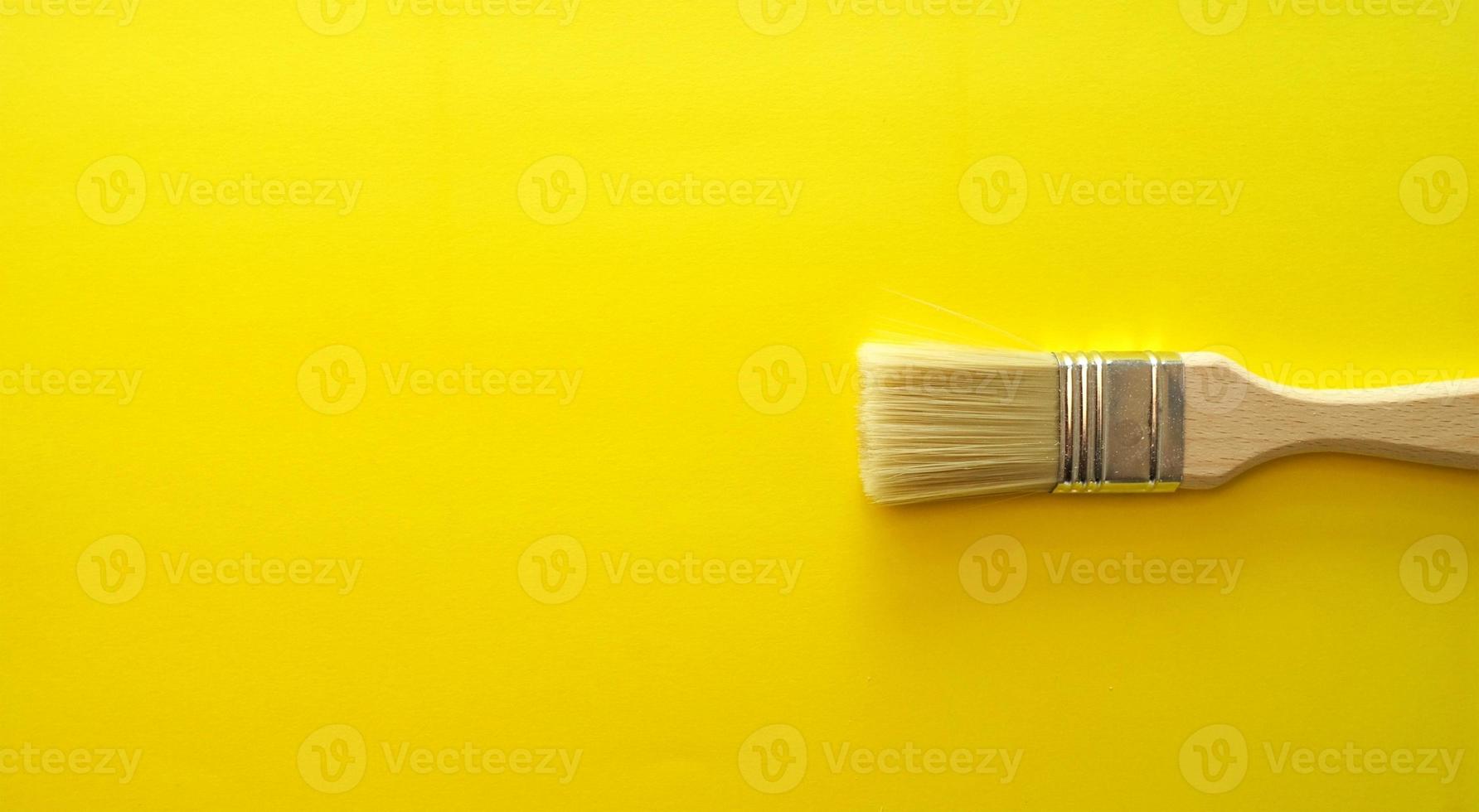 Banner amarillo brillante con pincel de madera artístico. foto
