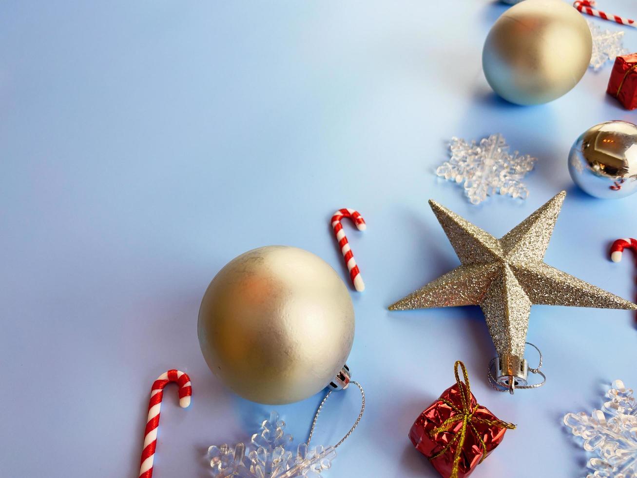 adornos navideños, caja de regalo, bolas doradas, copos de nieve sobre fondo azul. foto