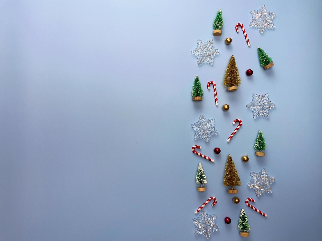 Vista superior de adornos navideños, pino, bolas rojas y doradas, copos de nieve sobre fondo azul. foto