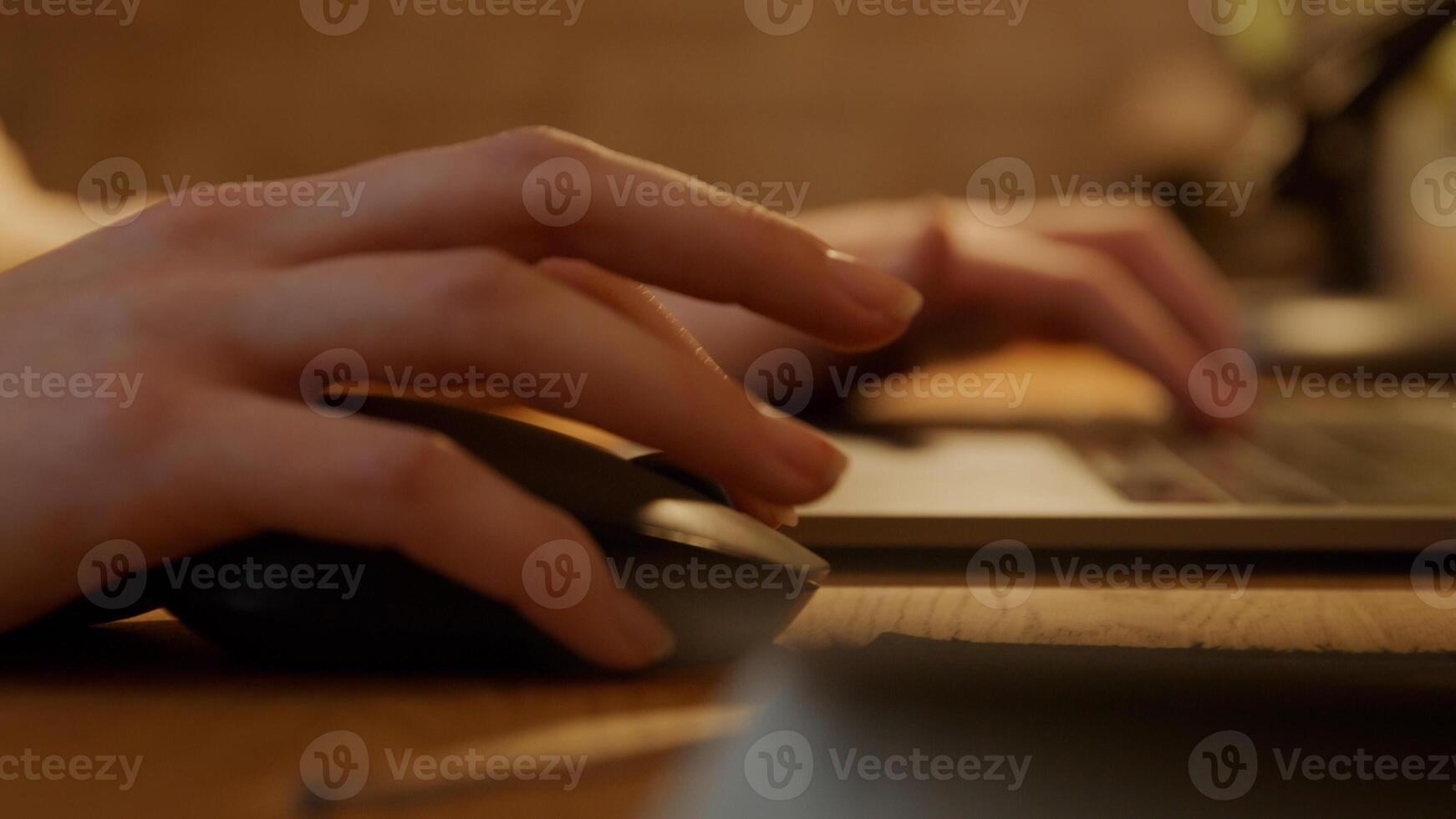 Close up of hands of young Middle Eastern man using computer mouse and typing on laptop photo