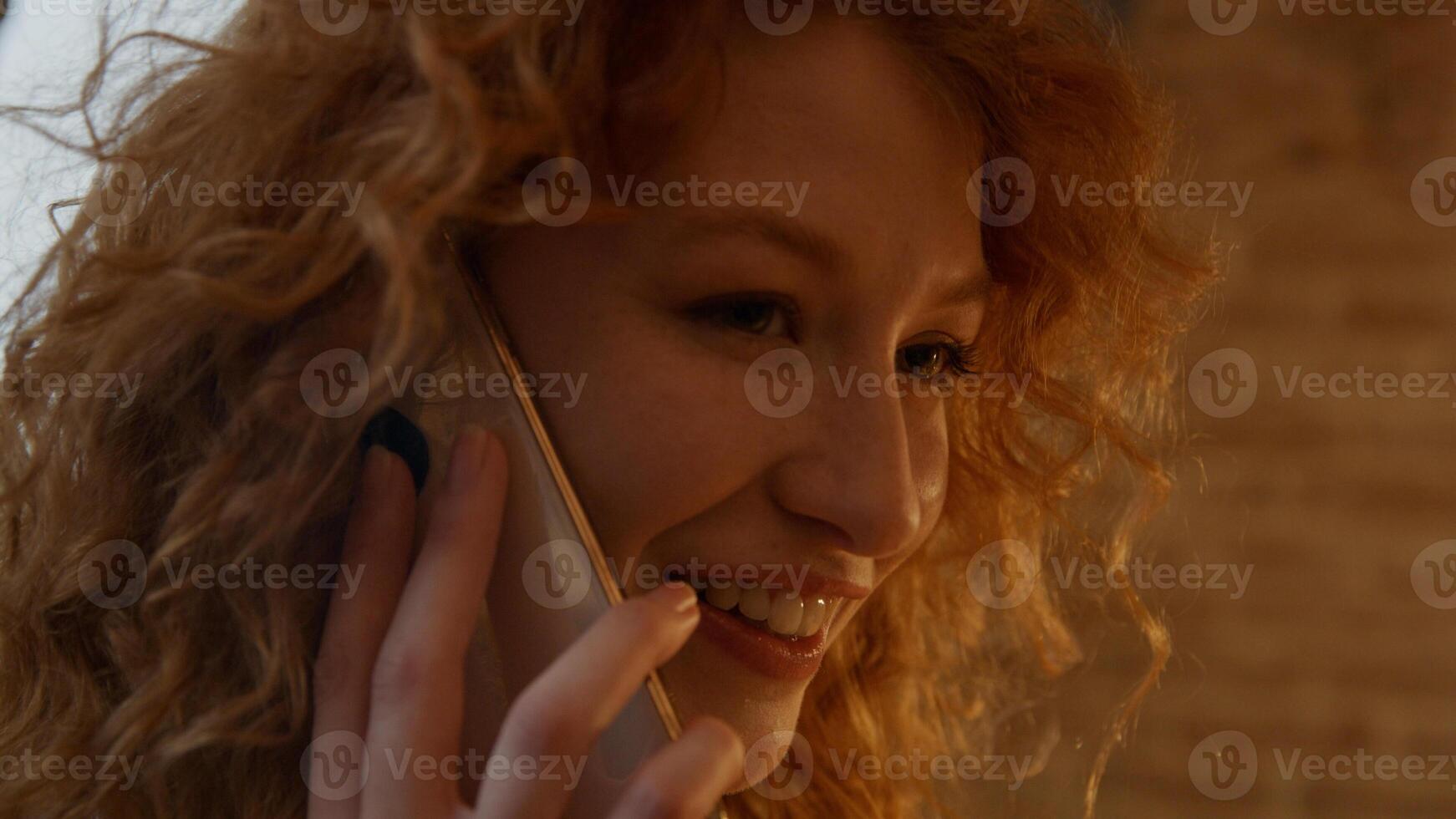 Close up of young white woman, calling with mobile phone, talking and smiling photo