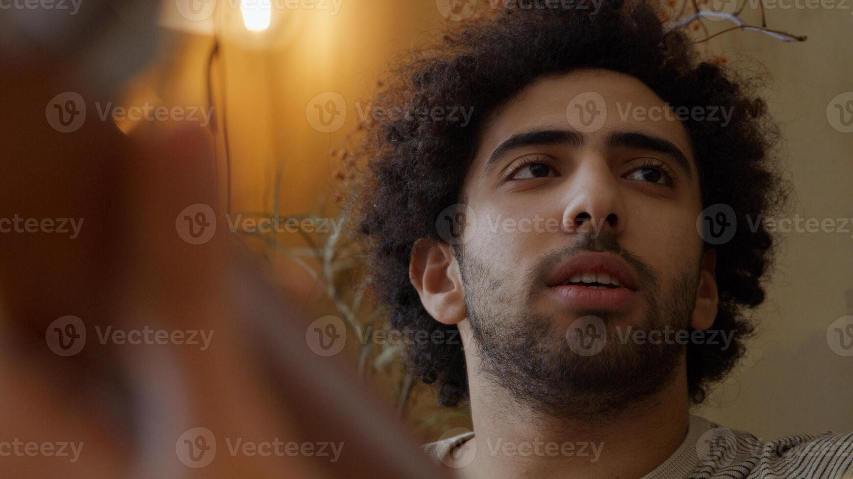 Headshot of young Middle Eastern man, talking to young mixed race woman who plays guitar photo