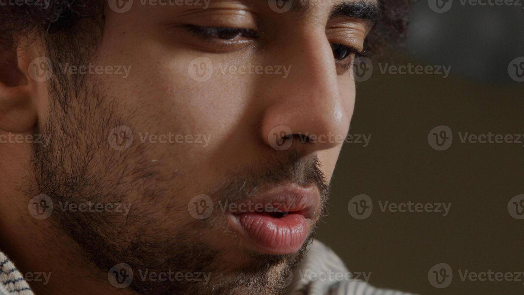 Extremo cerca del rostro del joven hombre de Oriente Medio, mirando enfocado foto