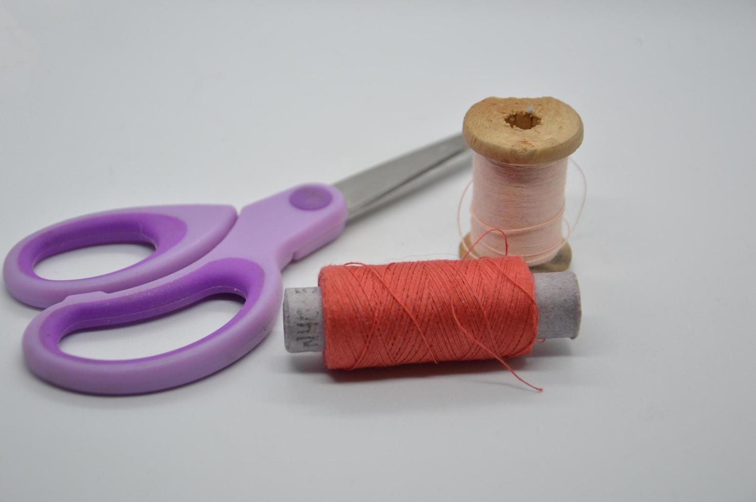 Hilos y carretes para coser ropa sobre un fondo blanco. foto