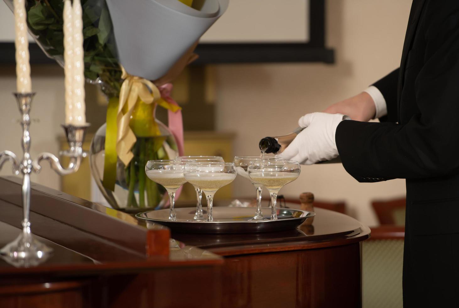 A tray with glasses of champagne and a bottle of sparkling wine. photo