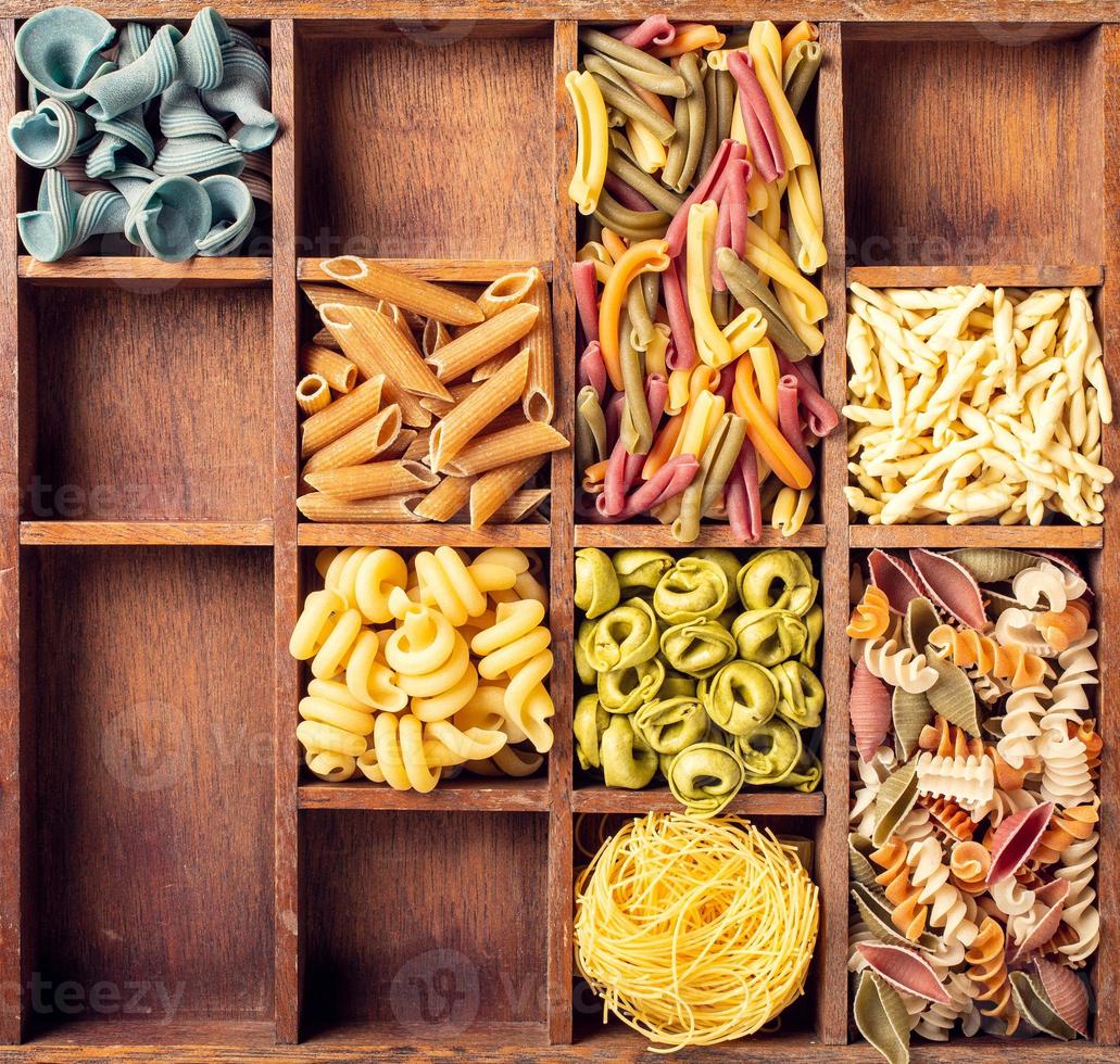 Assorted colorful italian pasta in wooden box photo