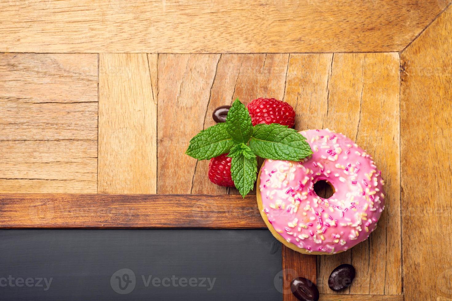 pizarra negra con rosquilla glaseada rosa foto