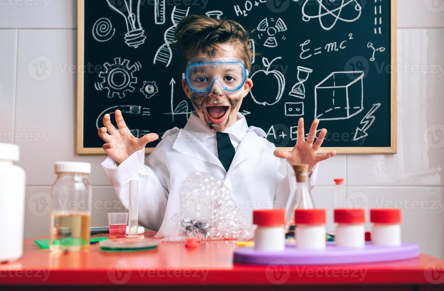 Happy little boy playing excited with experiment results photo