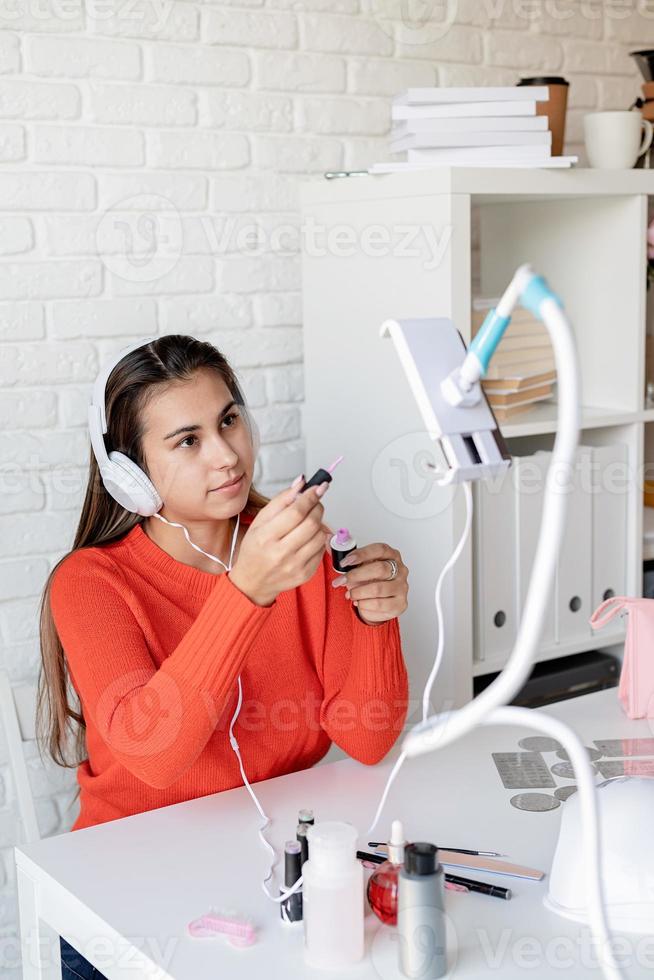 Hermosa influenciadora maestra de uñas caucásica con video chat o haciendo un blog foto