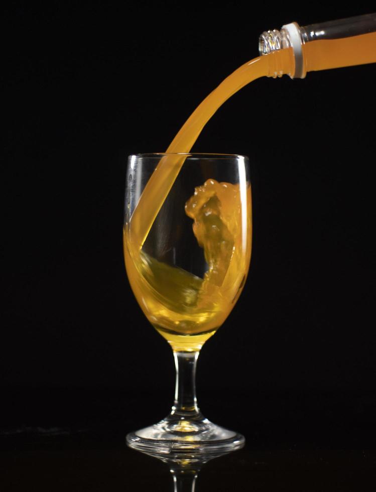 pour orange syrup into a glass photo